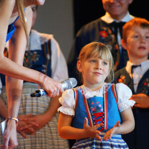 Nicole Galliker interviewt ein Kind der Trachtengruppe Gunzwil